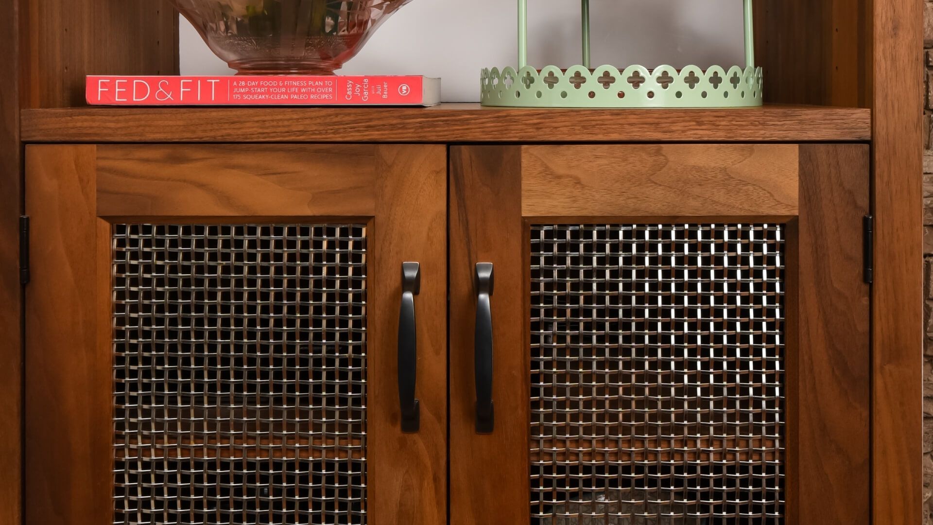 Custom cabinet featuring decorative woven wire mesh door inserts