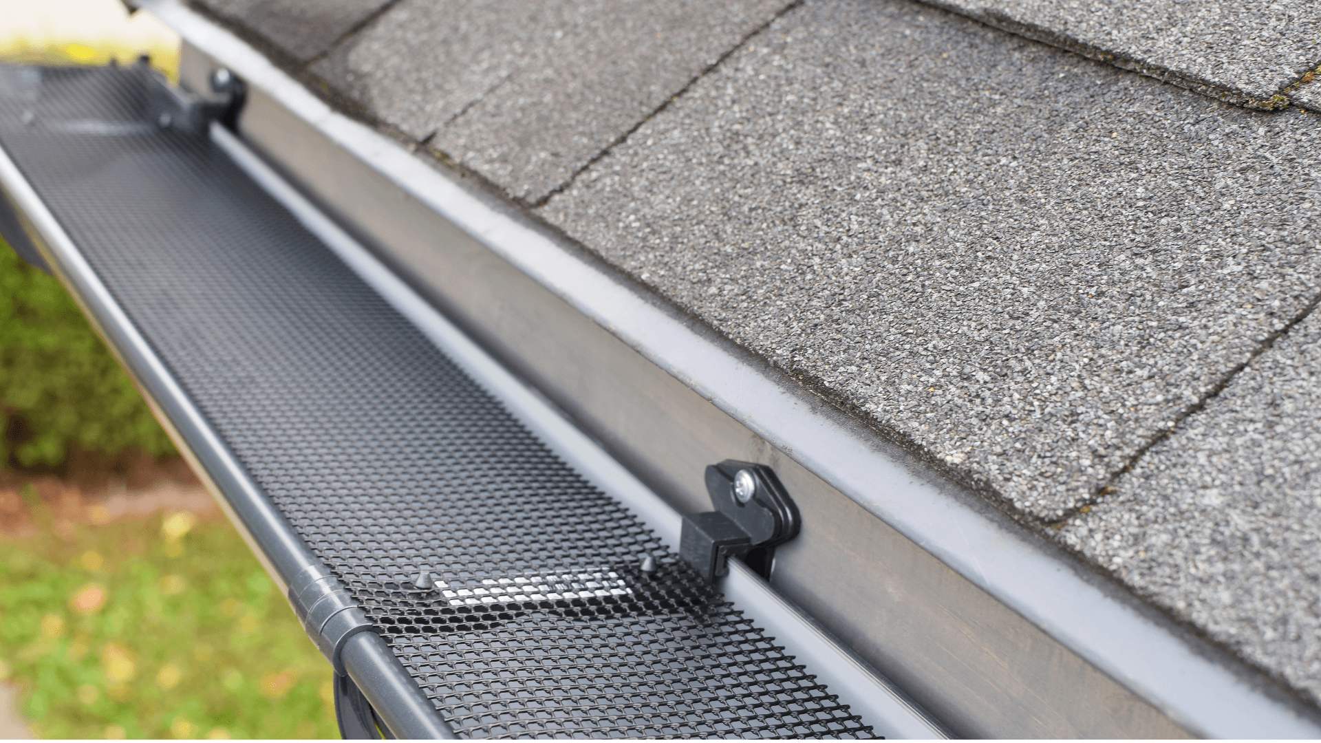 gutter guard mesh protecting gutter attached to the side of a house