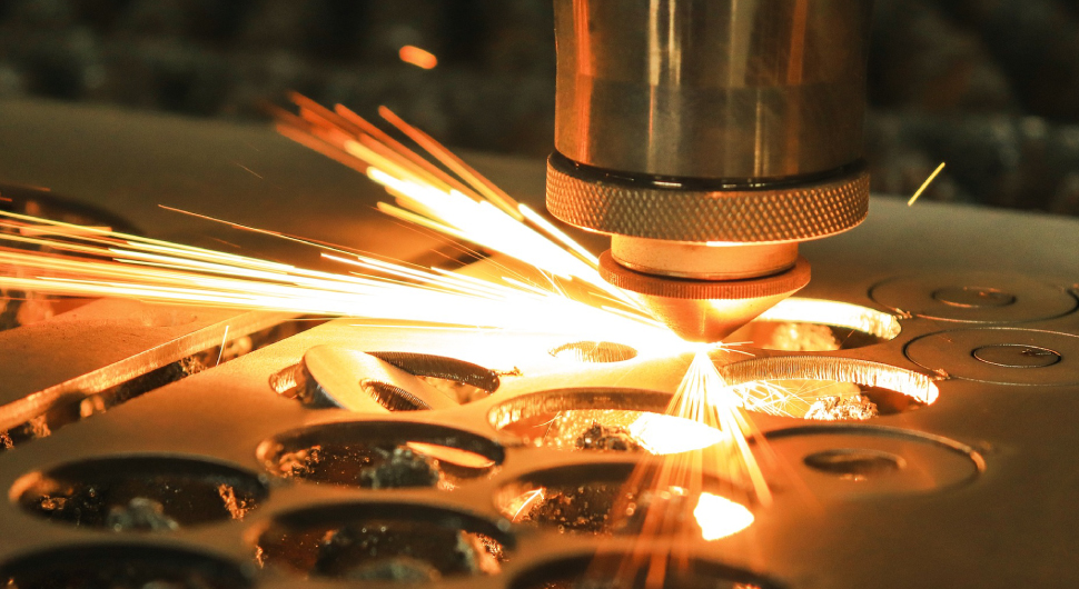 A laser cuts out circles of metal.
