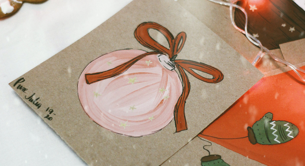 Handmade Christmas cards using craft paper are painted with colorful holiday decorations.