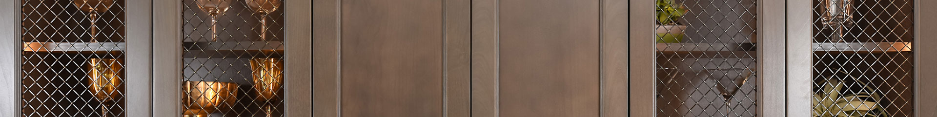 Close up of wood cabinet doors with wire mesh inserts