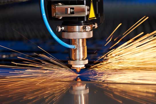Sparks fly from an industrial laser as it cuts metal wire mesh. 