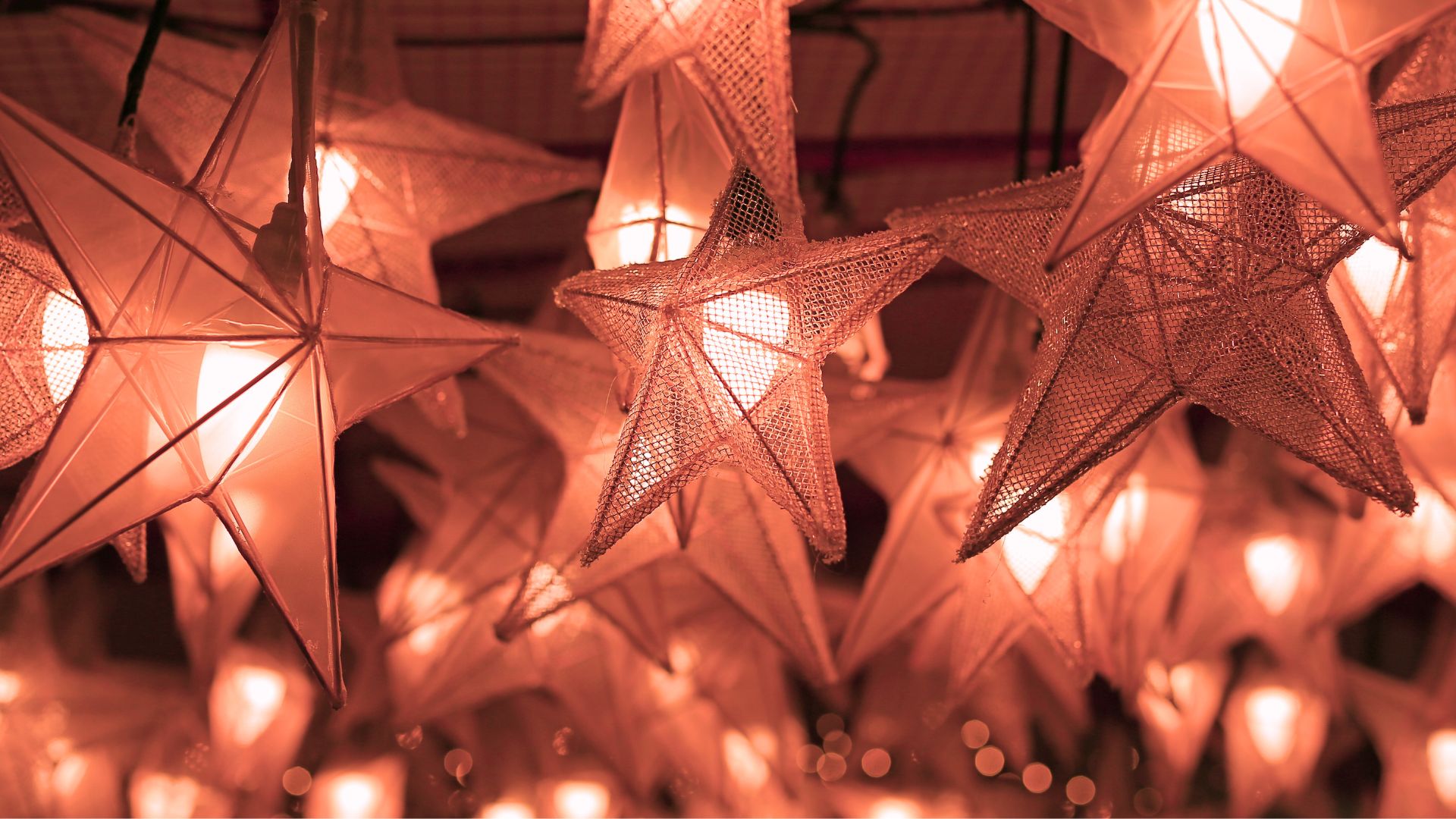 Copper wire mesh hanging light fixtures in the shapes of starts.