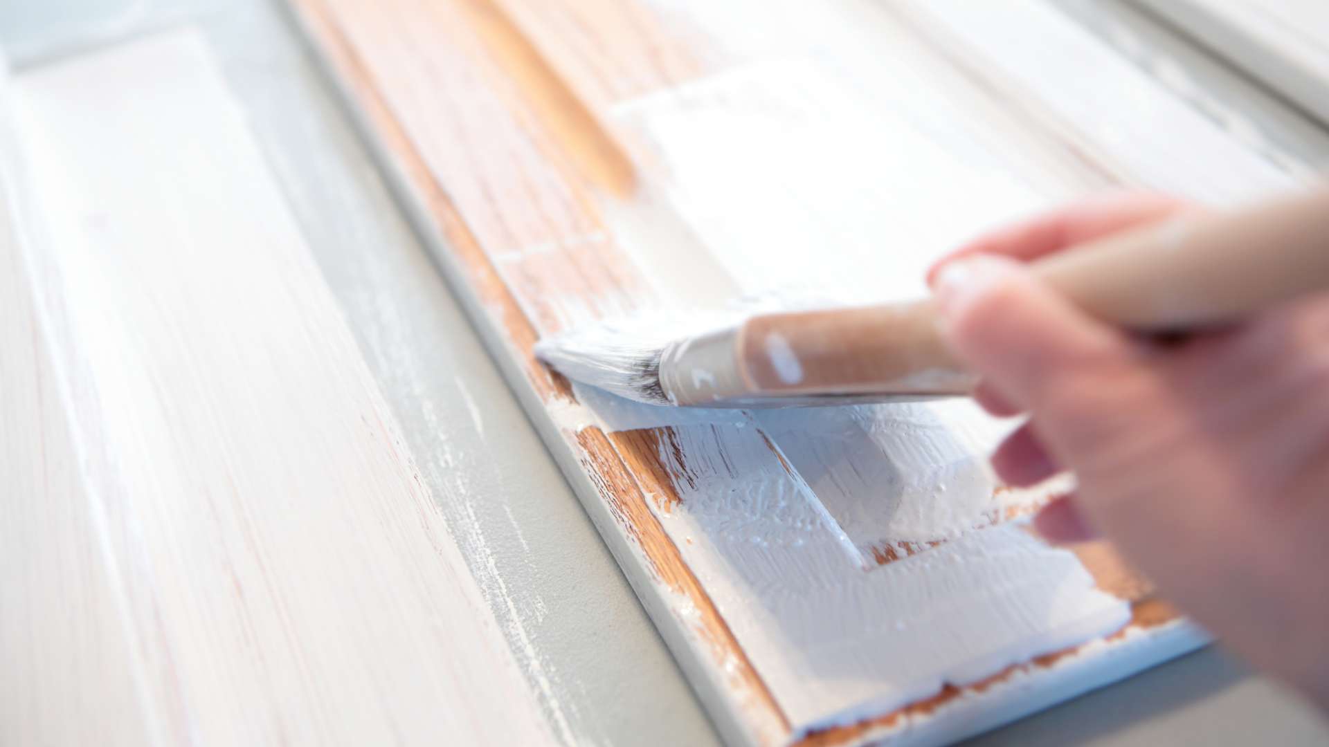 painting kitchen cabinets white with paintbrush