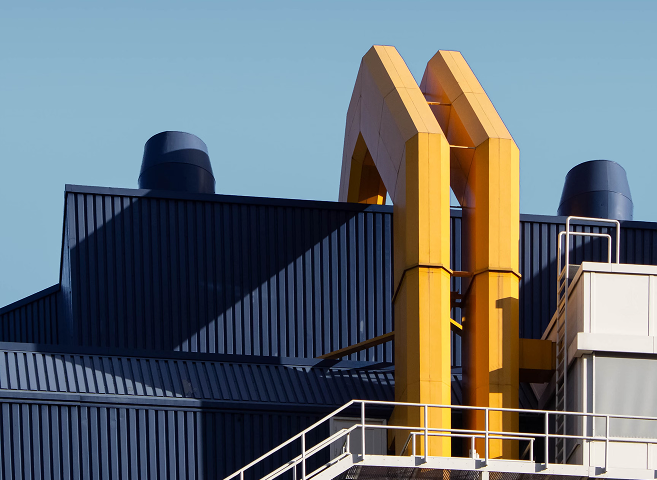 A modern industrial building featuring prominent yellow piping or ductwork