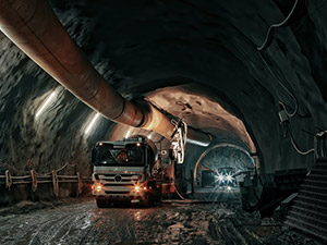 Truck in the dark tunnel in an underground mining operation.